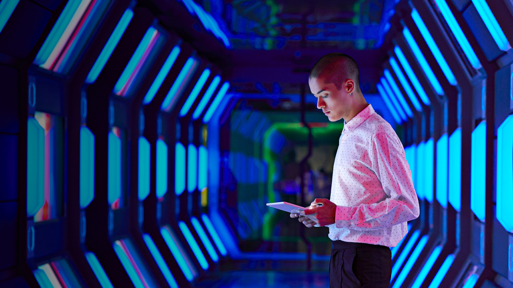 Wissen und Inspiration Blog Mann steht in einem blauen Tunnel und schaut auf ein Tablet