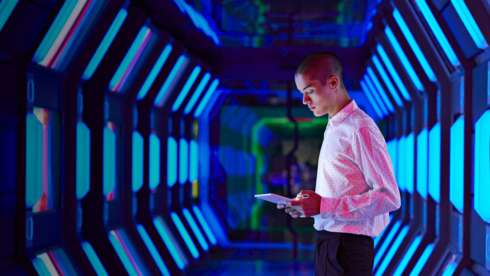 Wissen und Inspiration Blog Mann steht in einem blauen Tunnel und schaut auf ein Tablet